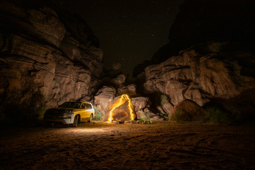 a truck parked in front of a large rock formation