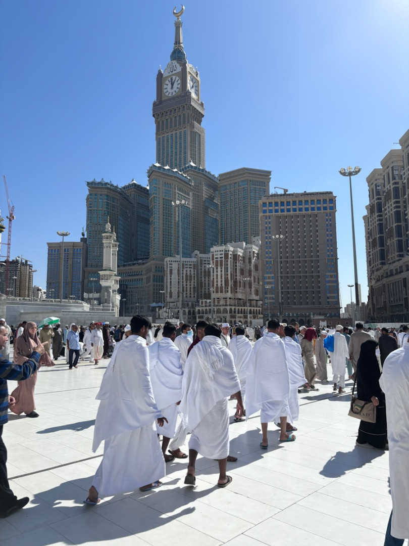 A group of people dressed in white walking through a city