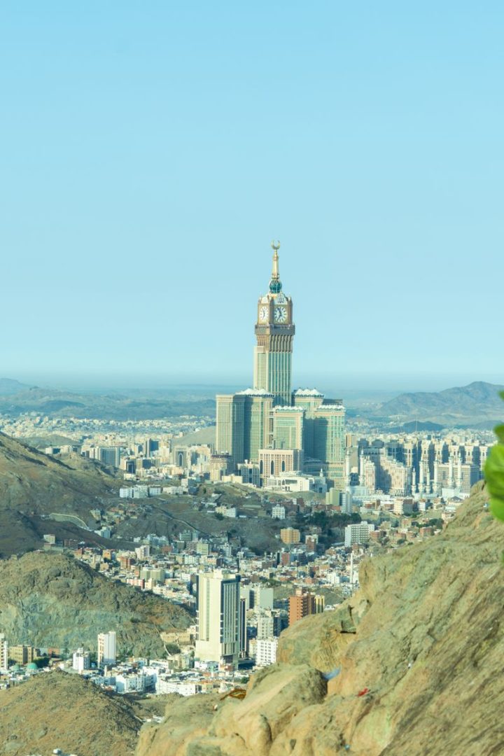 A breathtaking view of Makkah featuring the iconic Abraj Al Bait Towers against mountainous terrain.